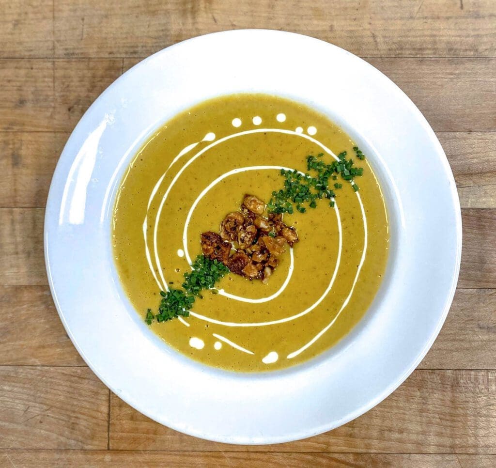 Pumpkin curry soup with crème fraiche and candied hazelnuts